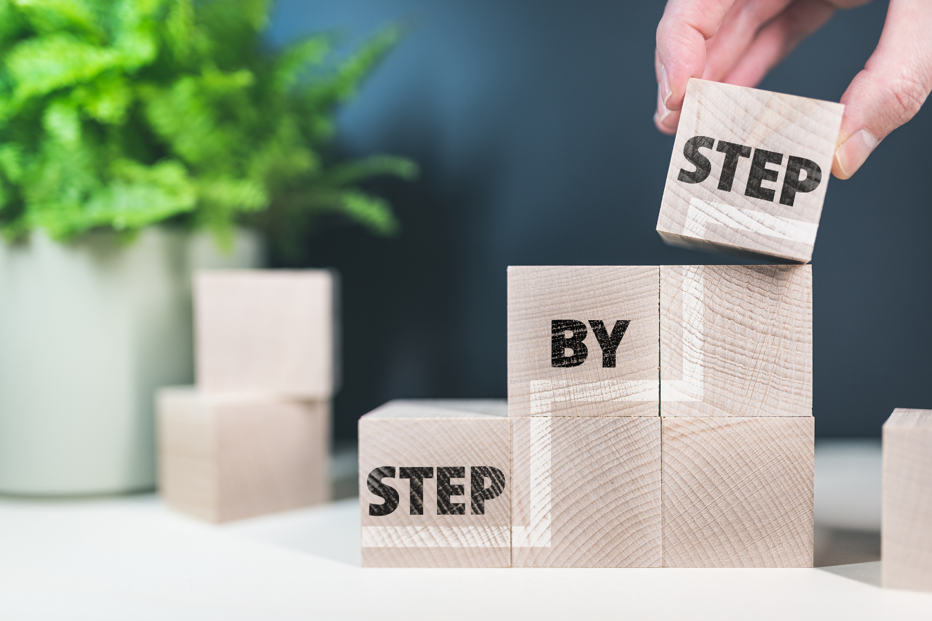 Blocks that say 'step by step' representing the 7 steps in our guide to becoming a marketing consultant.