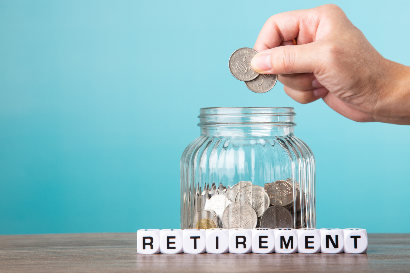 Putting money into a jar to represent retirement savings.
