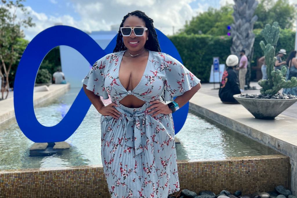 fractional CMO Aniesia Williams posing in front of a giant Meta logo